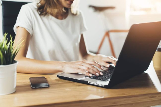 Woman writing on laptop